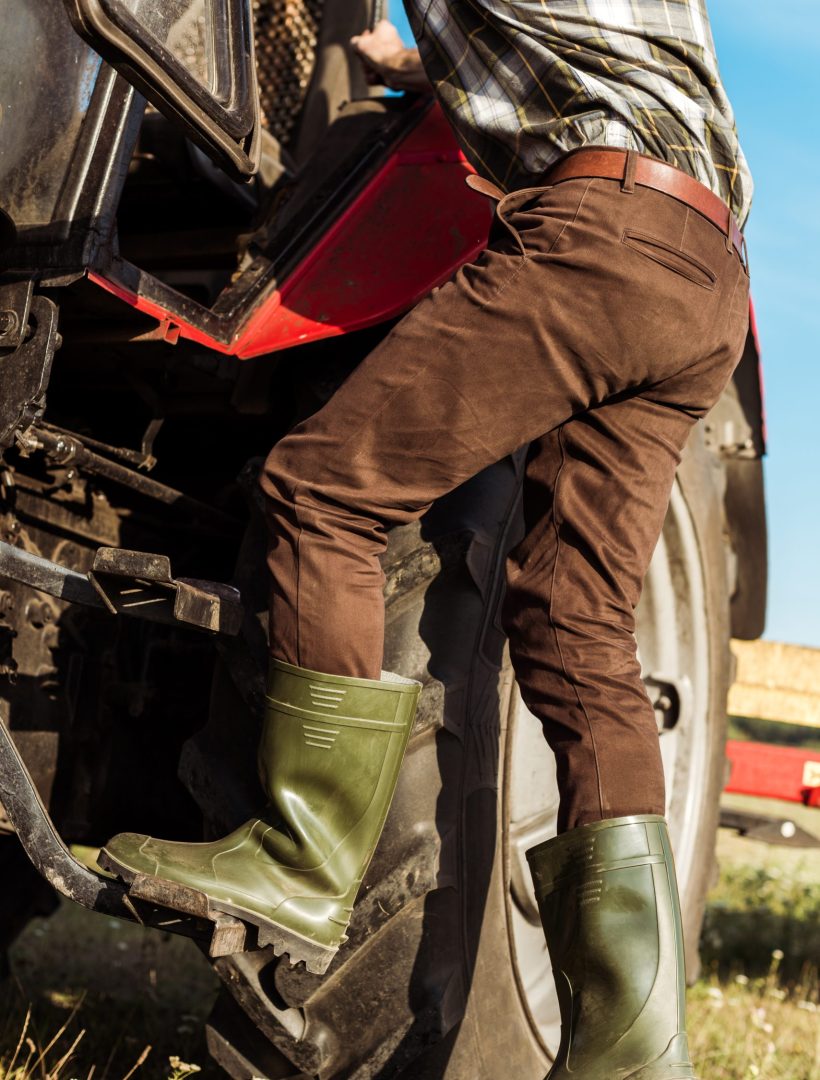 cropped view of self-employed farmer near modern tractor